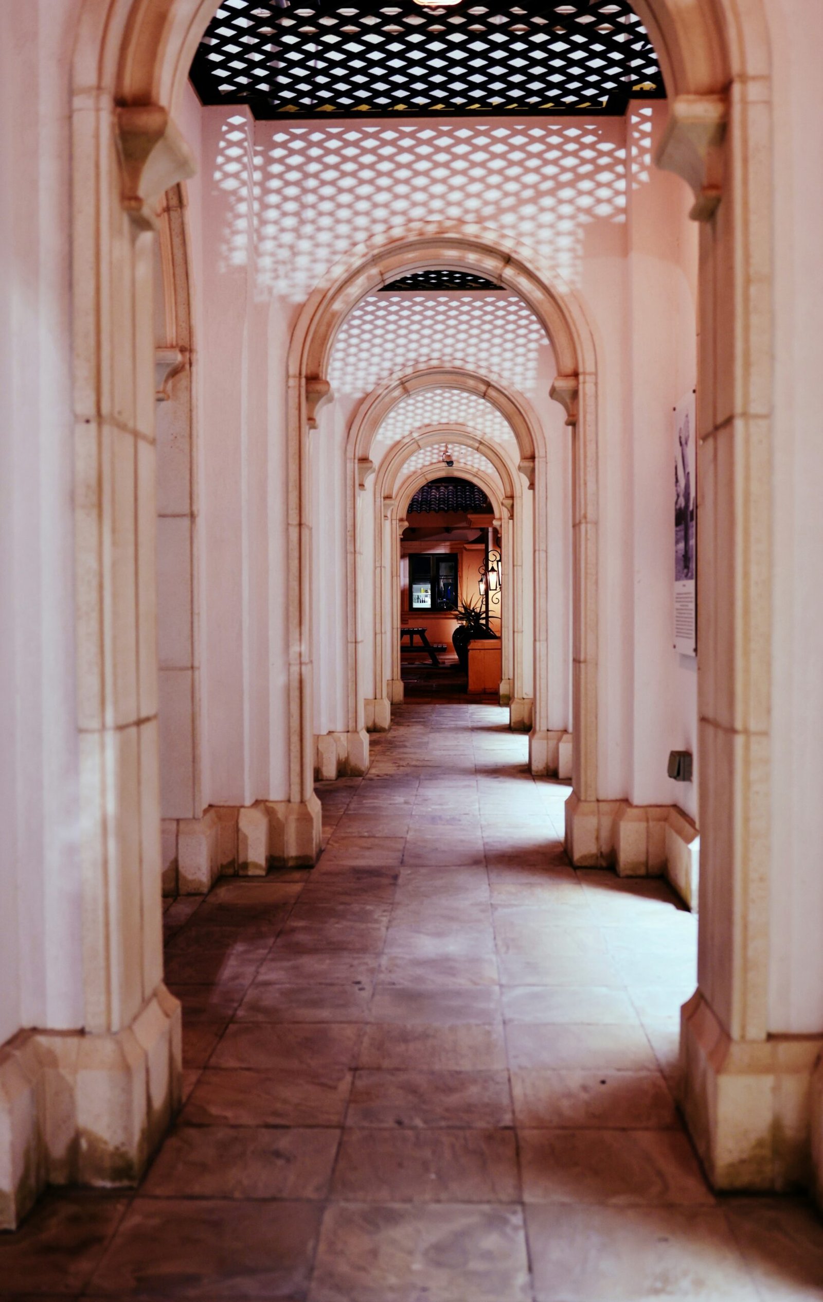 a long hallway with arches and a clock on the wall